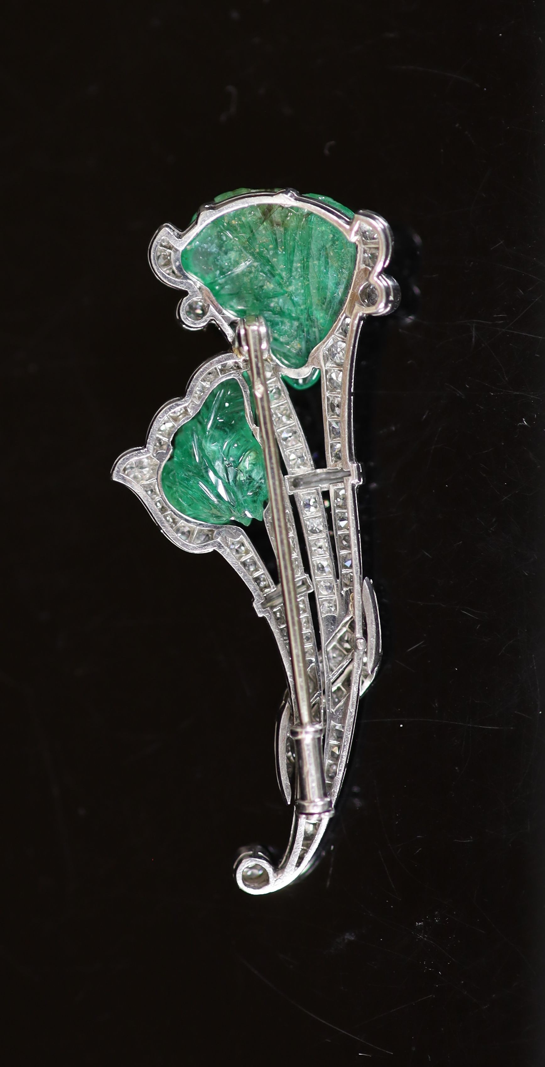 A 1940's French 18ct white gold, carved emerald, baguette and round cut diamond set floral spray brooch(a.f.)